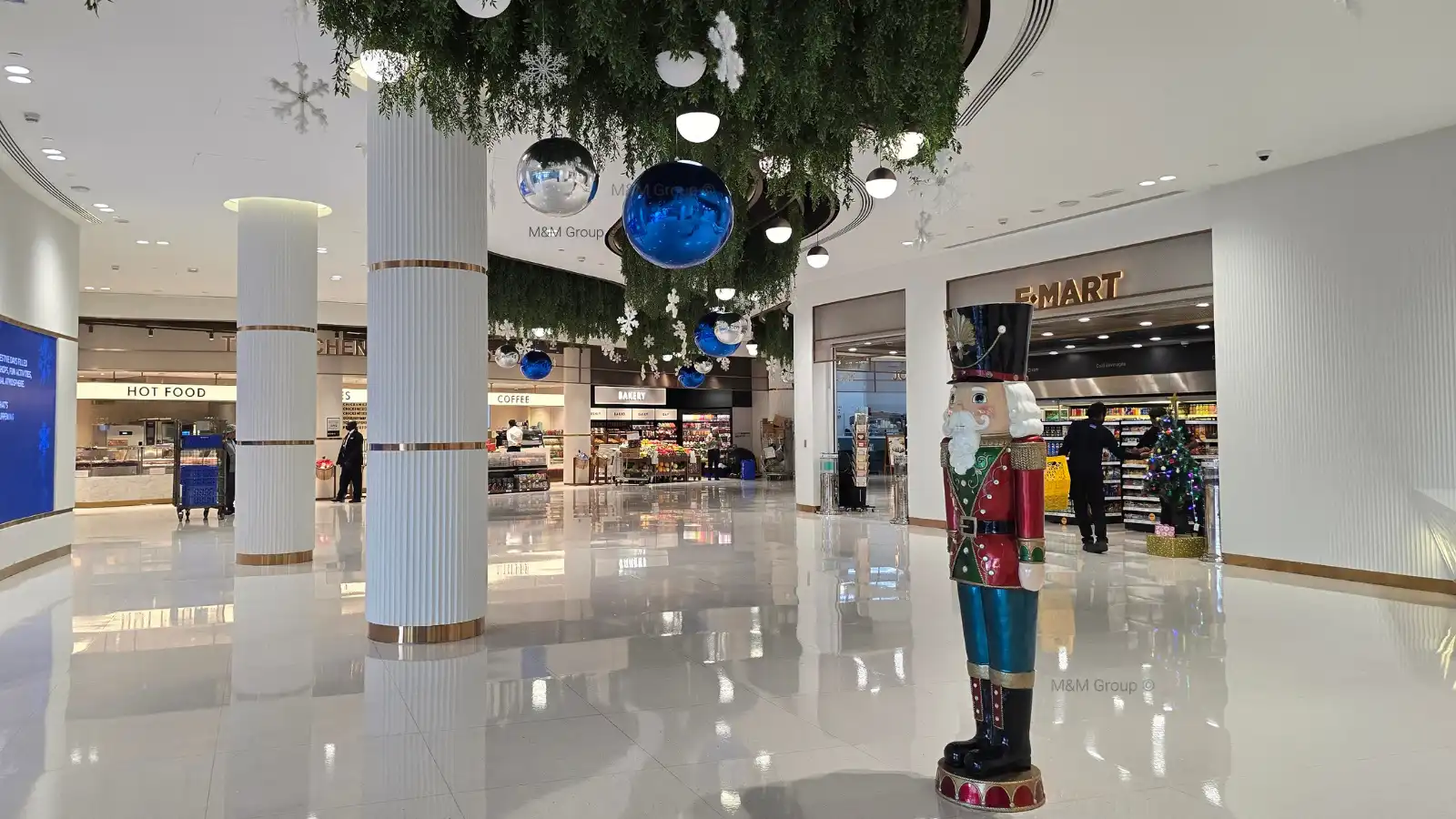 ديكور Food Court في مهرجان الشتاء في DAFZ مع كرات زرقاء وفضية معلقة وثلوج وزينة كسارة البندق في دبي