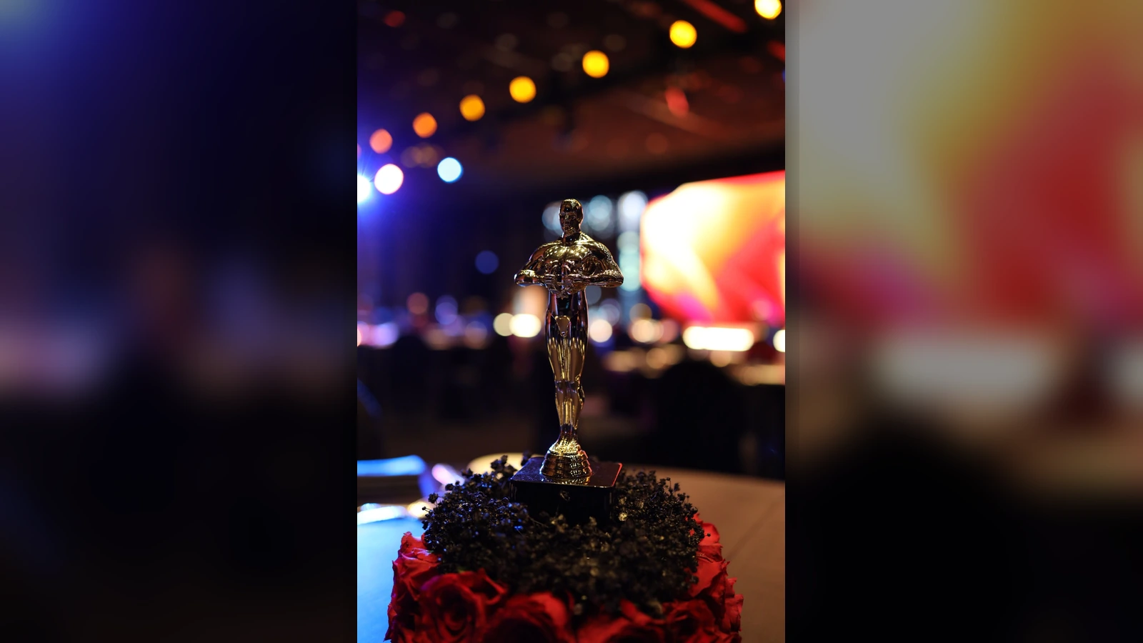 Gold award-style table centerpiece with red roses for First Response Healthcare Oscars-themed gala dinner in Dubai